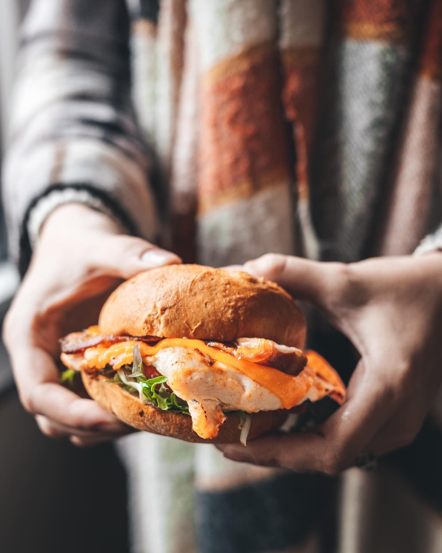 holding chicken sandwich out for photo