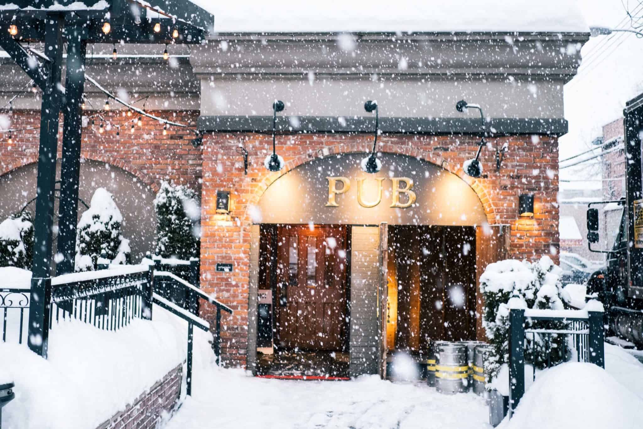 exterior of pub with snow flying from the skies