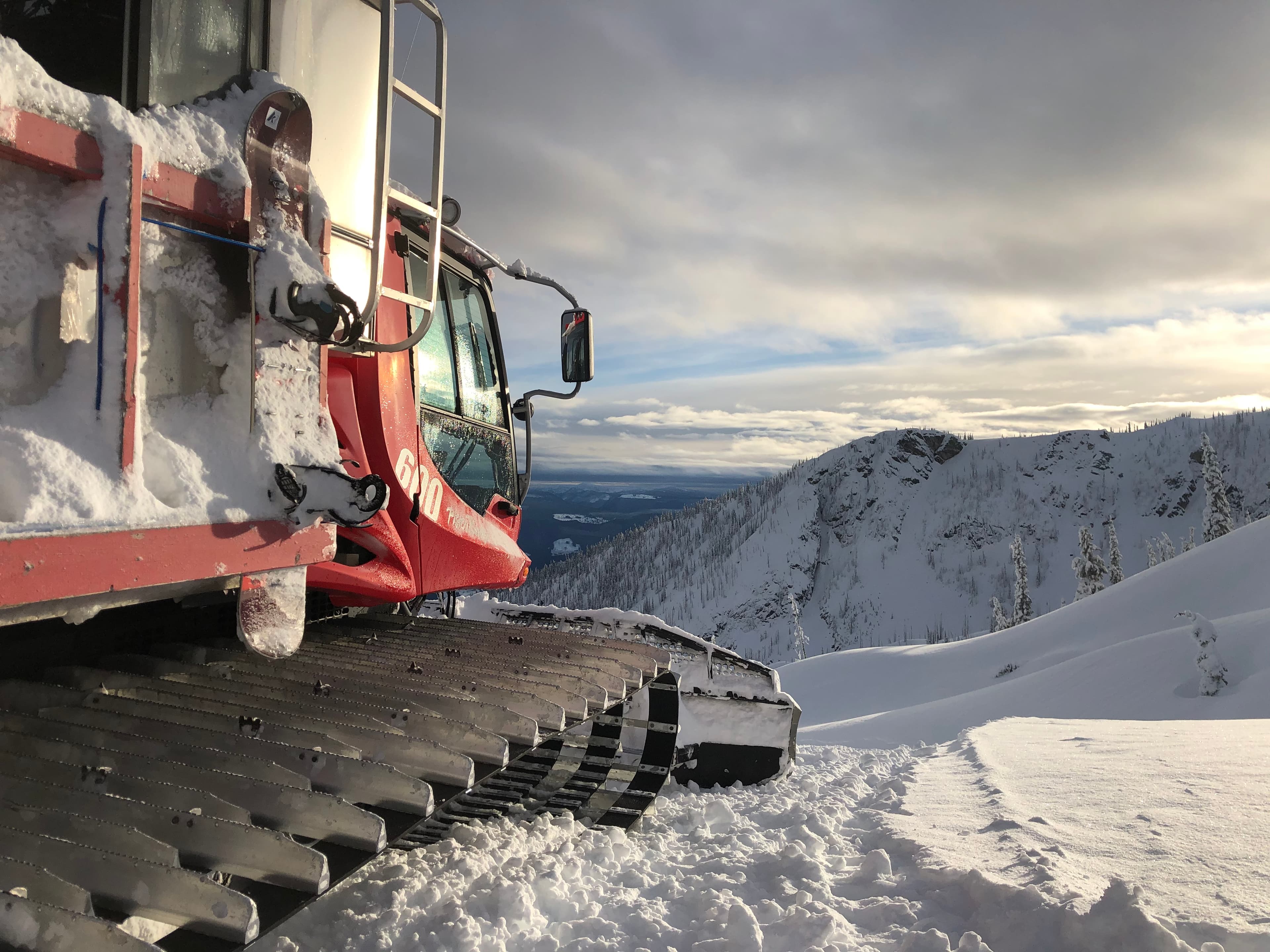 cat skiing groomer at the top of ridge looking out to valley