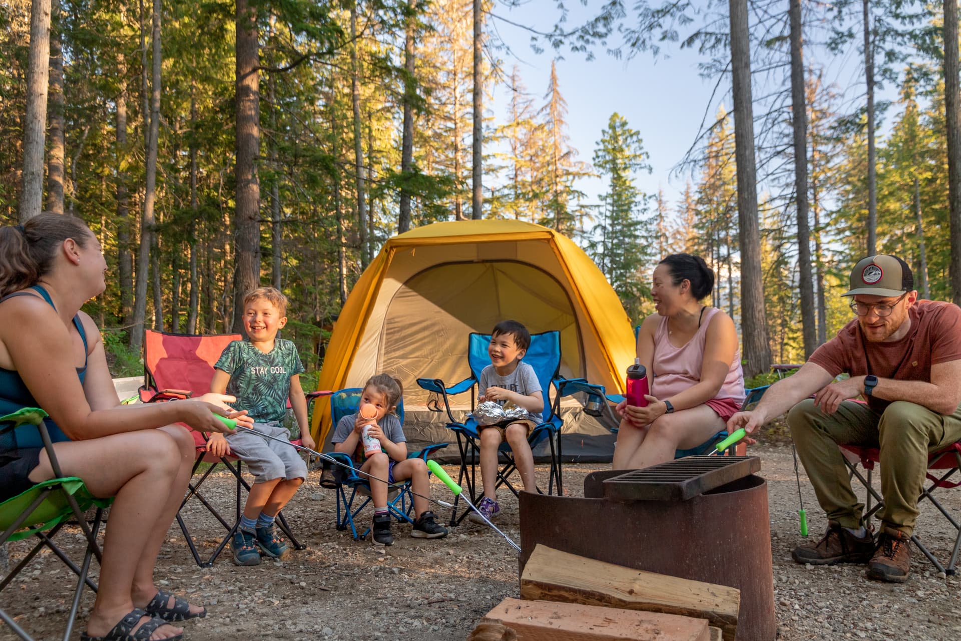 family tent camping around fire pit