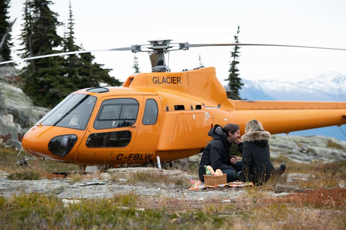 couple having picnic next to helicopter