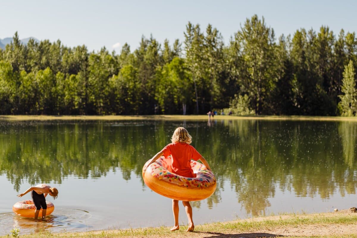 kid running towards man made lake with donut tube