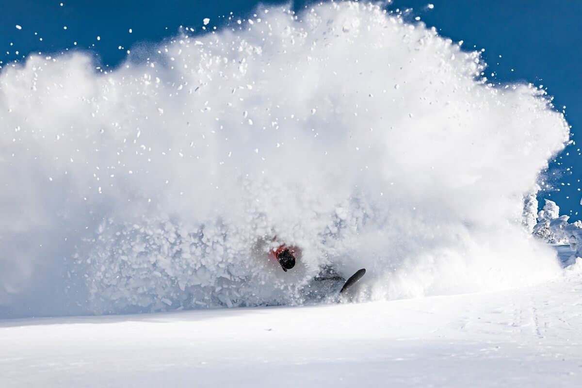 snowboarder slashing pow