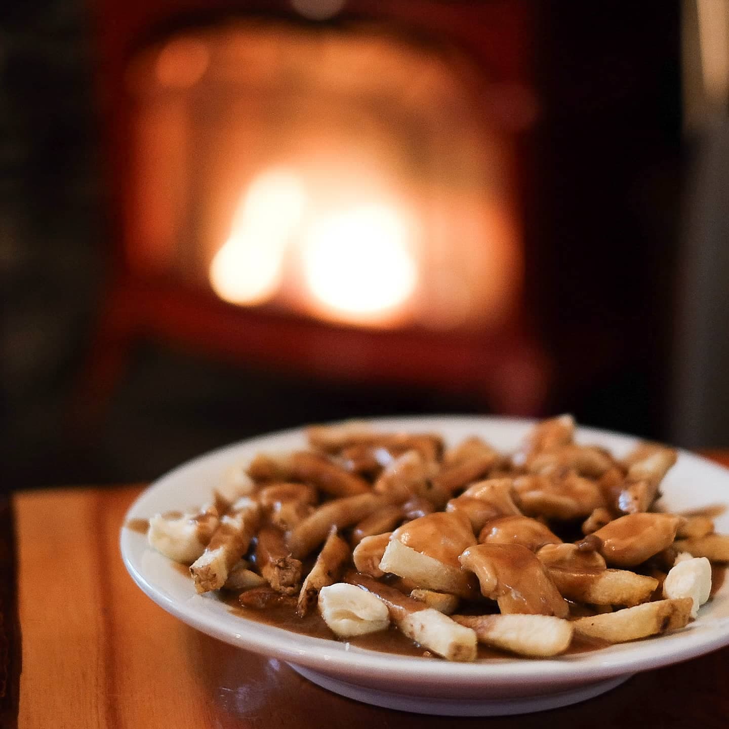 poutine in front of cozy fireplace