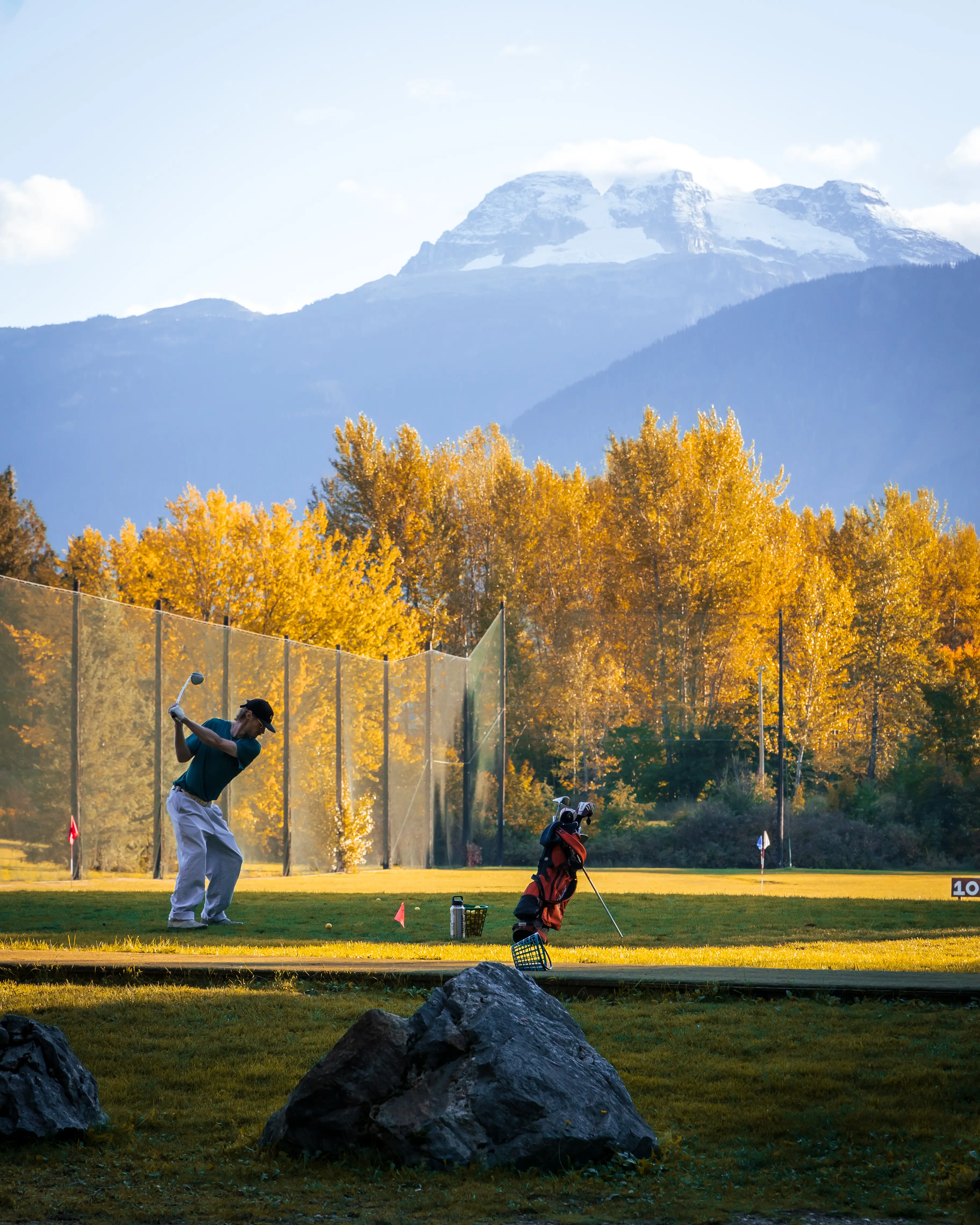 man lining up a shot at the driving range