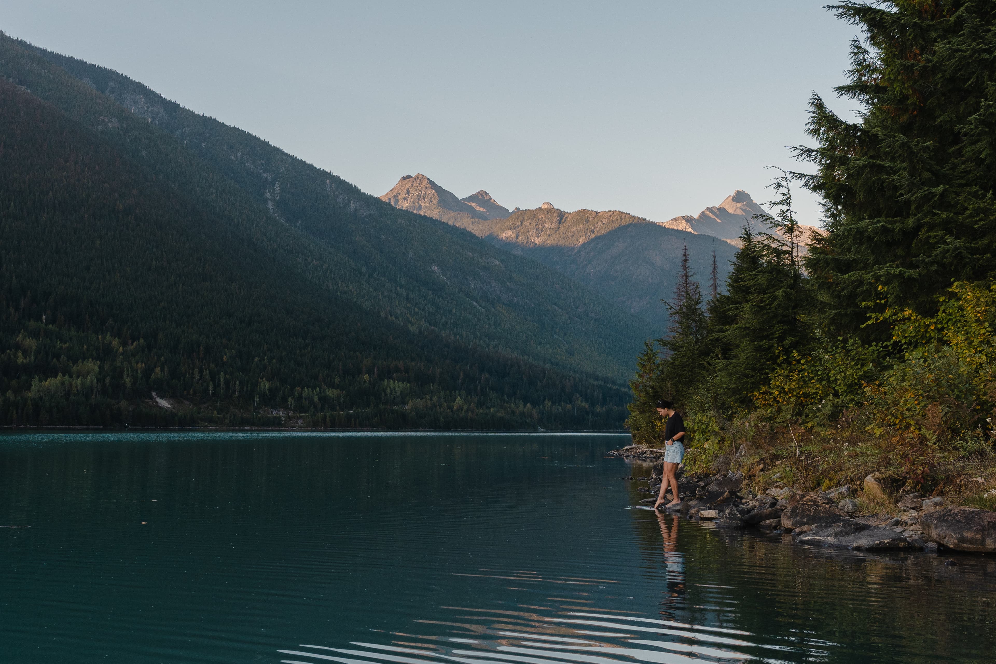 Girl dip toe in lake revelstoke