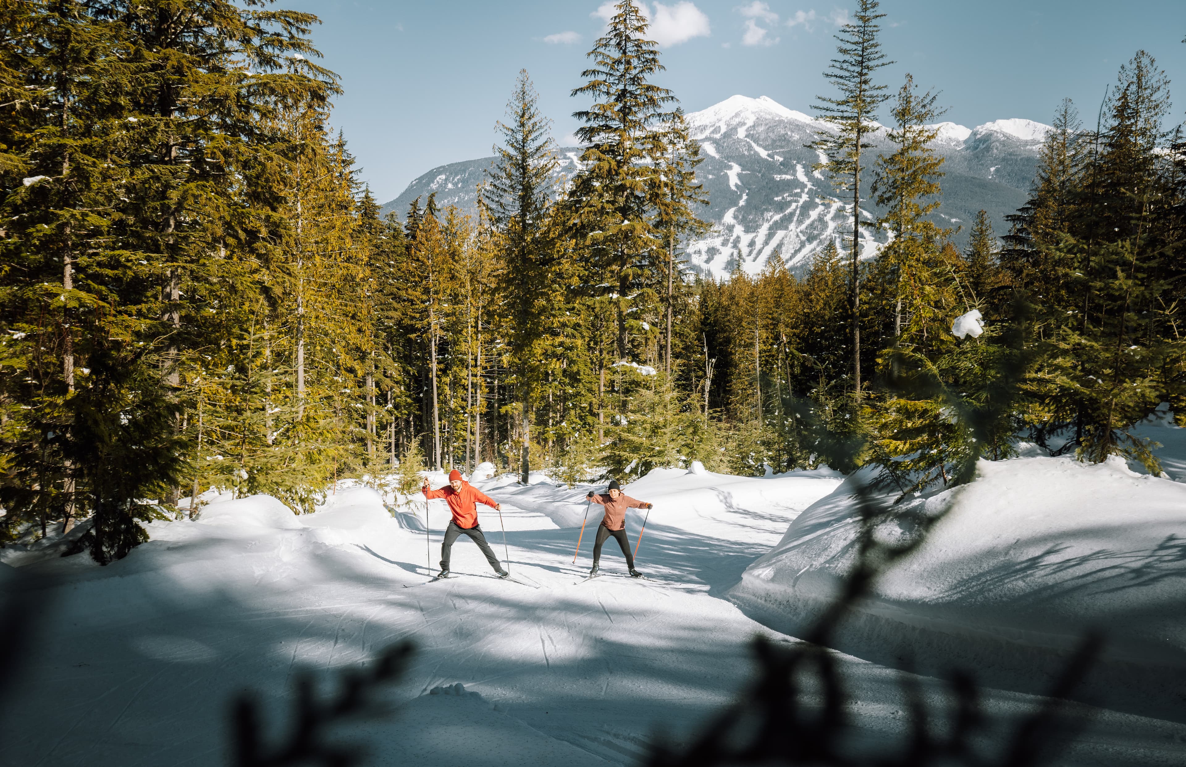 A couple makes their way up hill on cross country skis