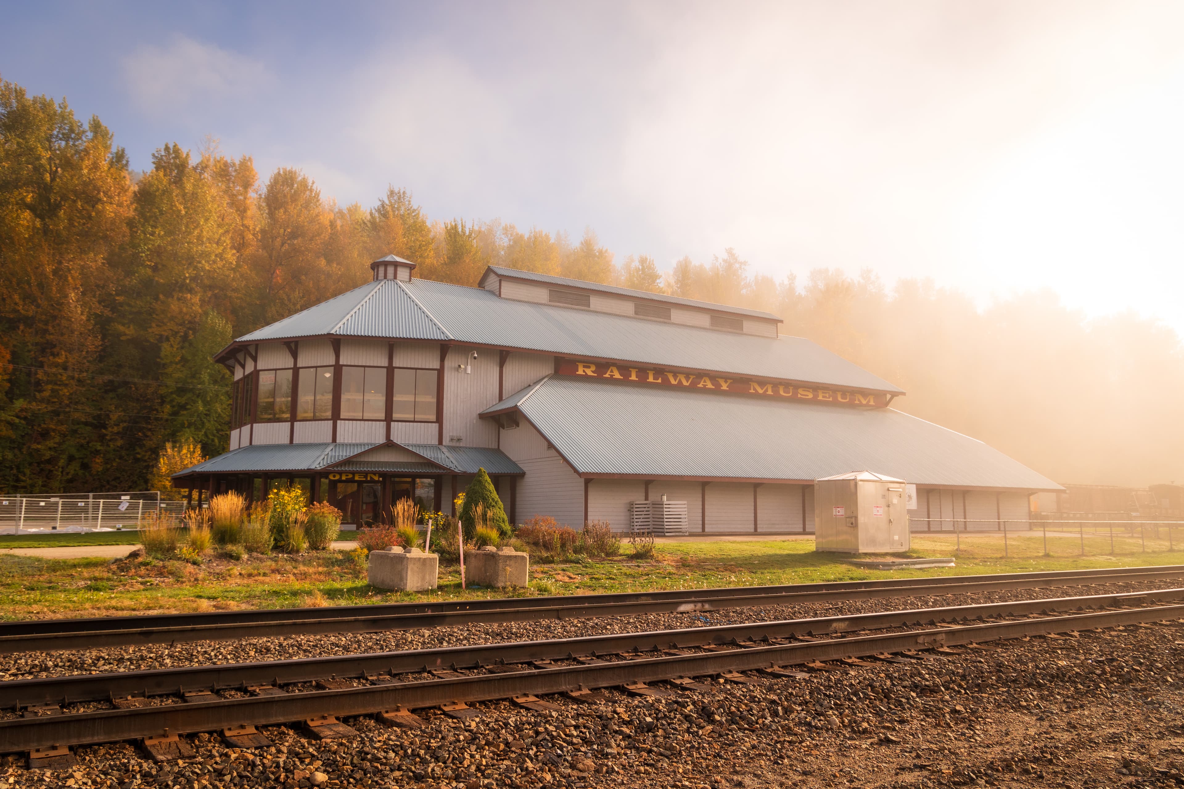fall coloured trees surronding museum and railway tracks