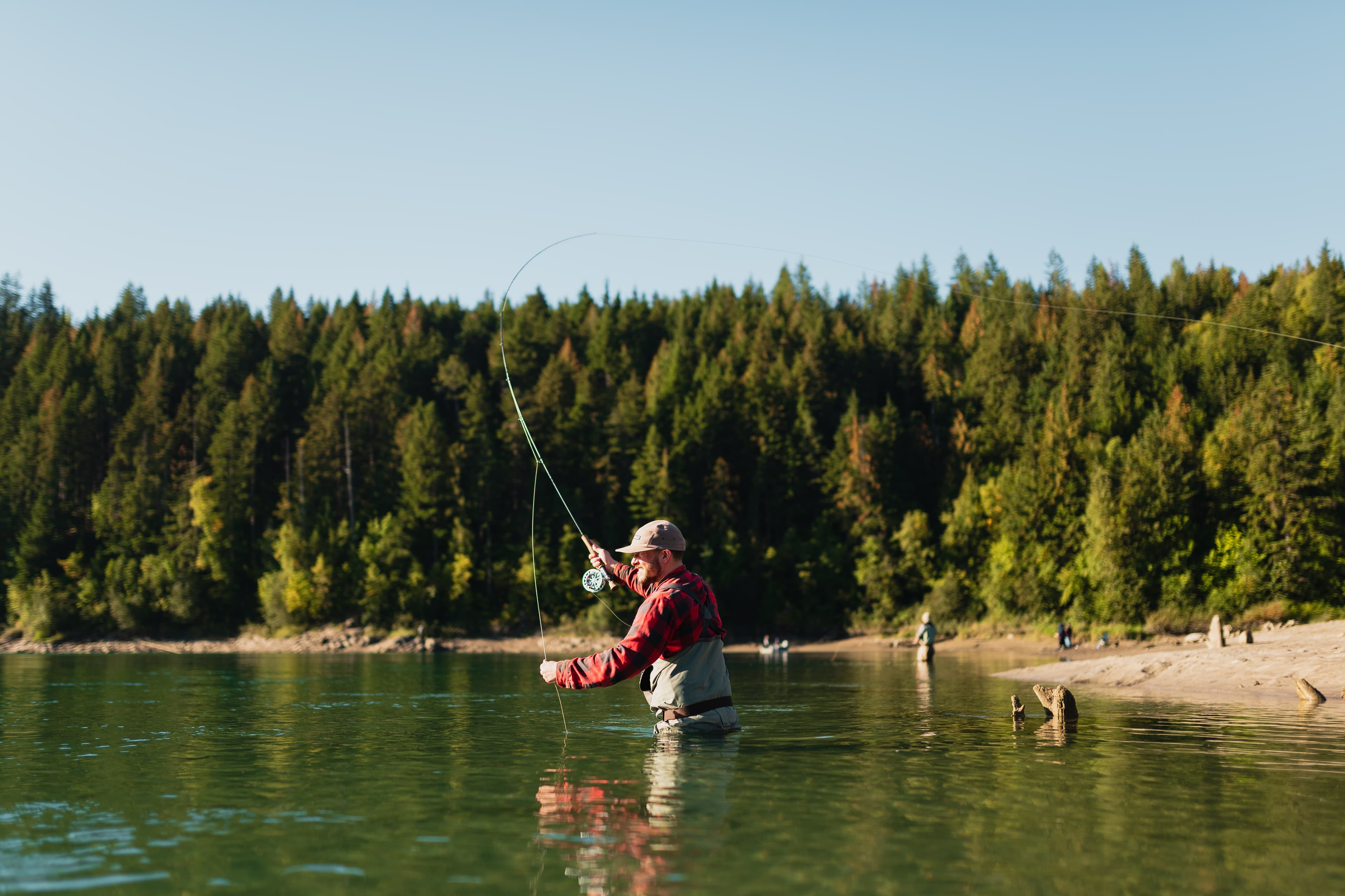 fly fisher hip deep in water fishing