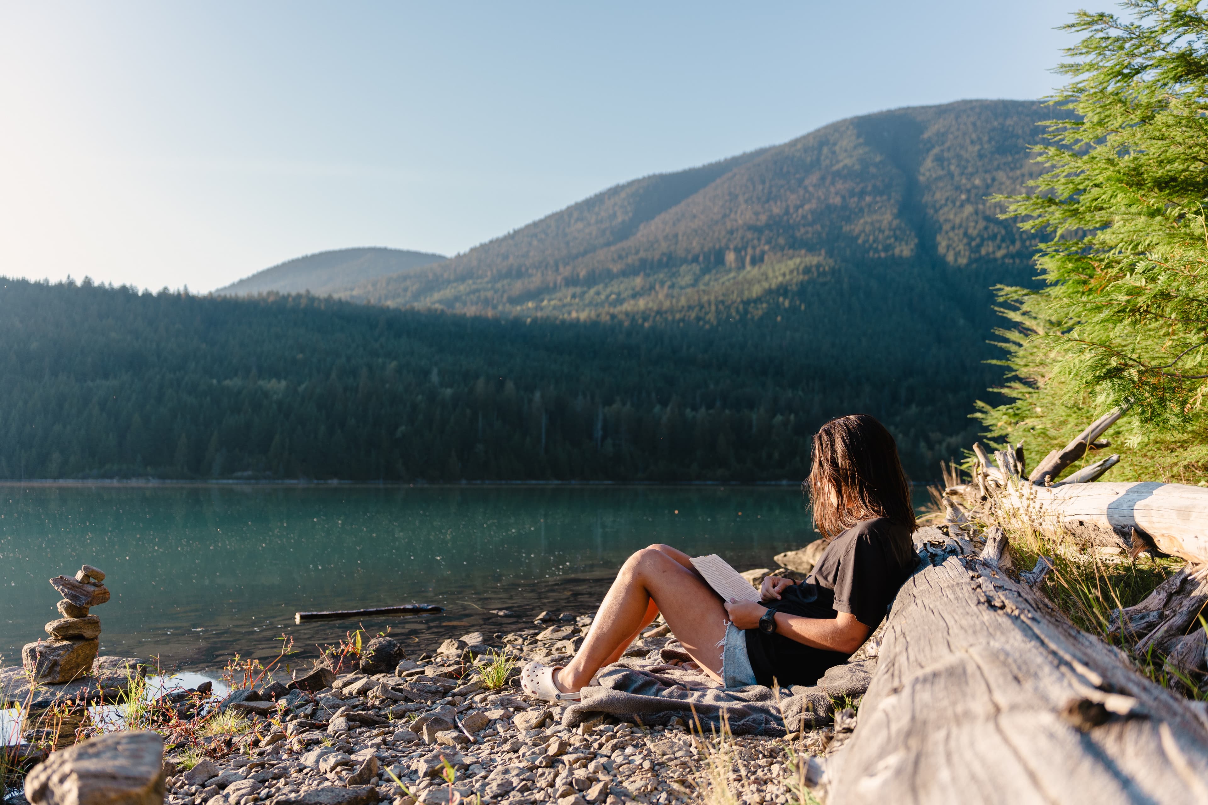 Girl reading booking at lake revelstoke