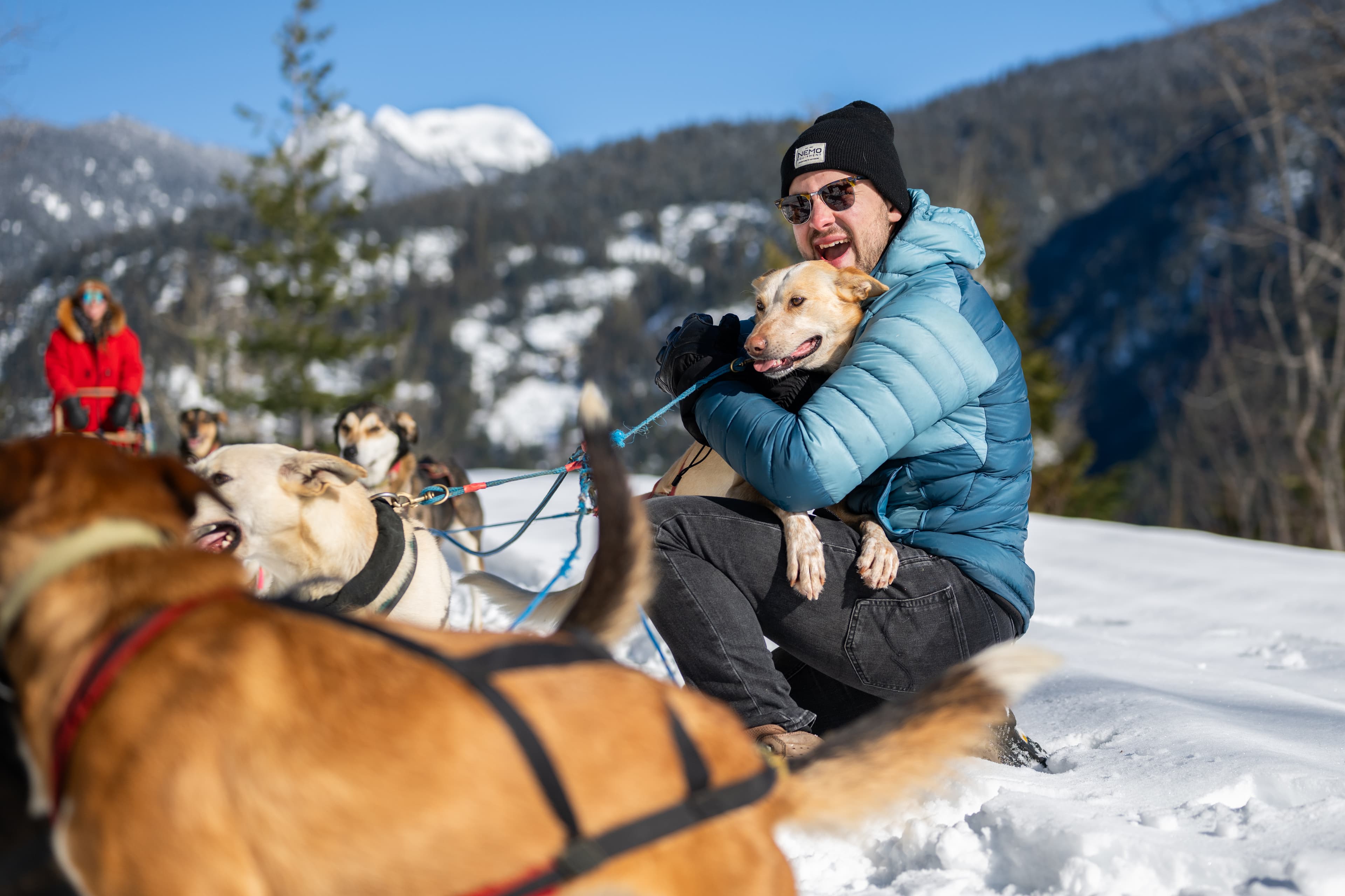 guy cuddling sled dog