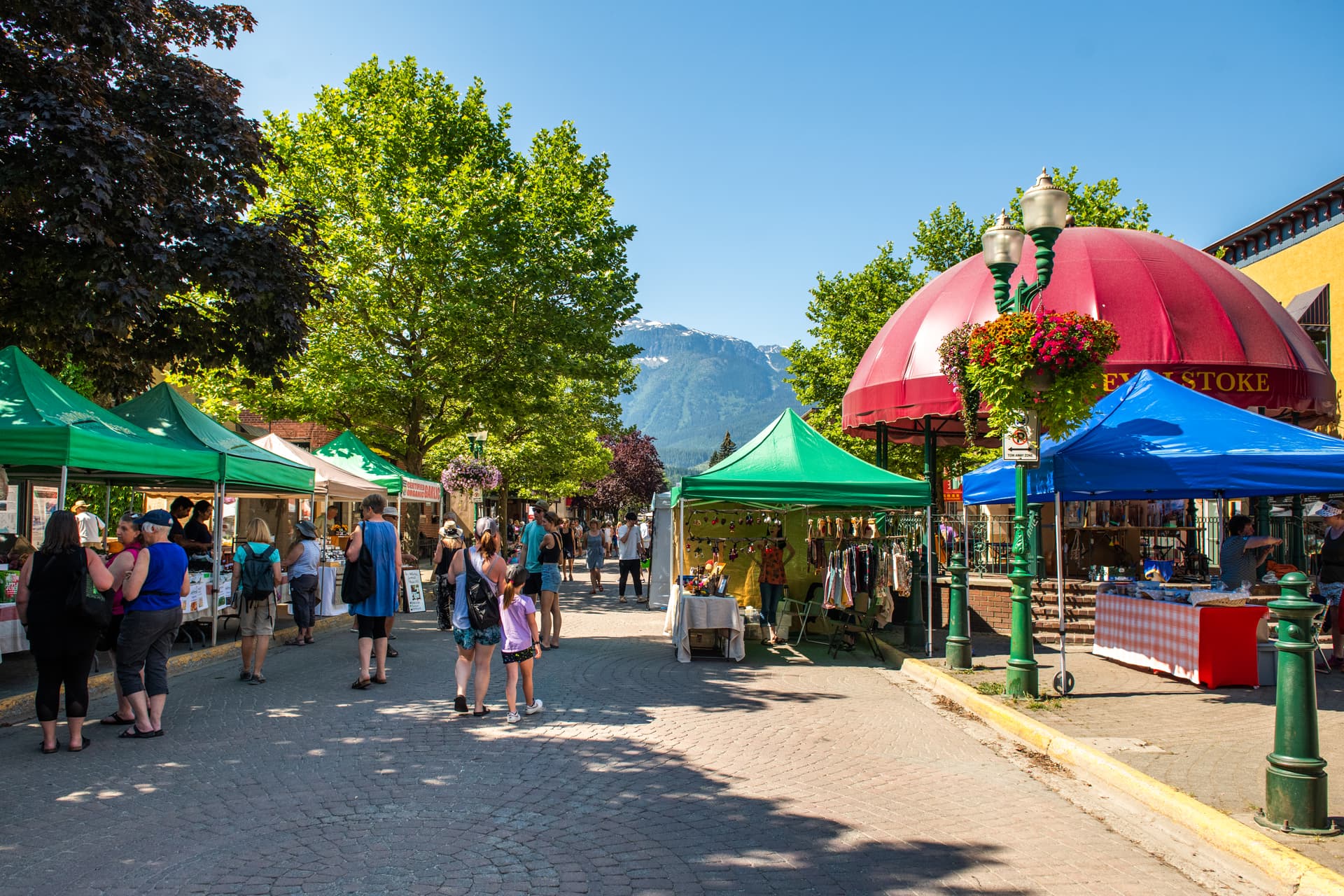 people walking through farmers market stands