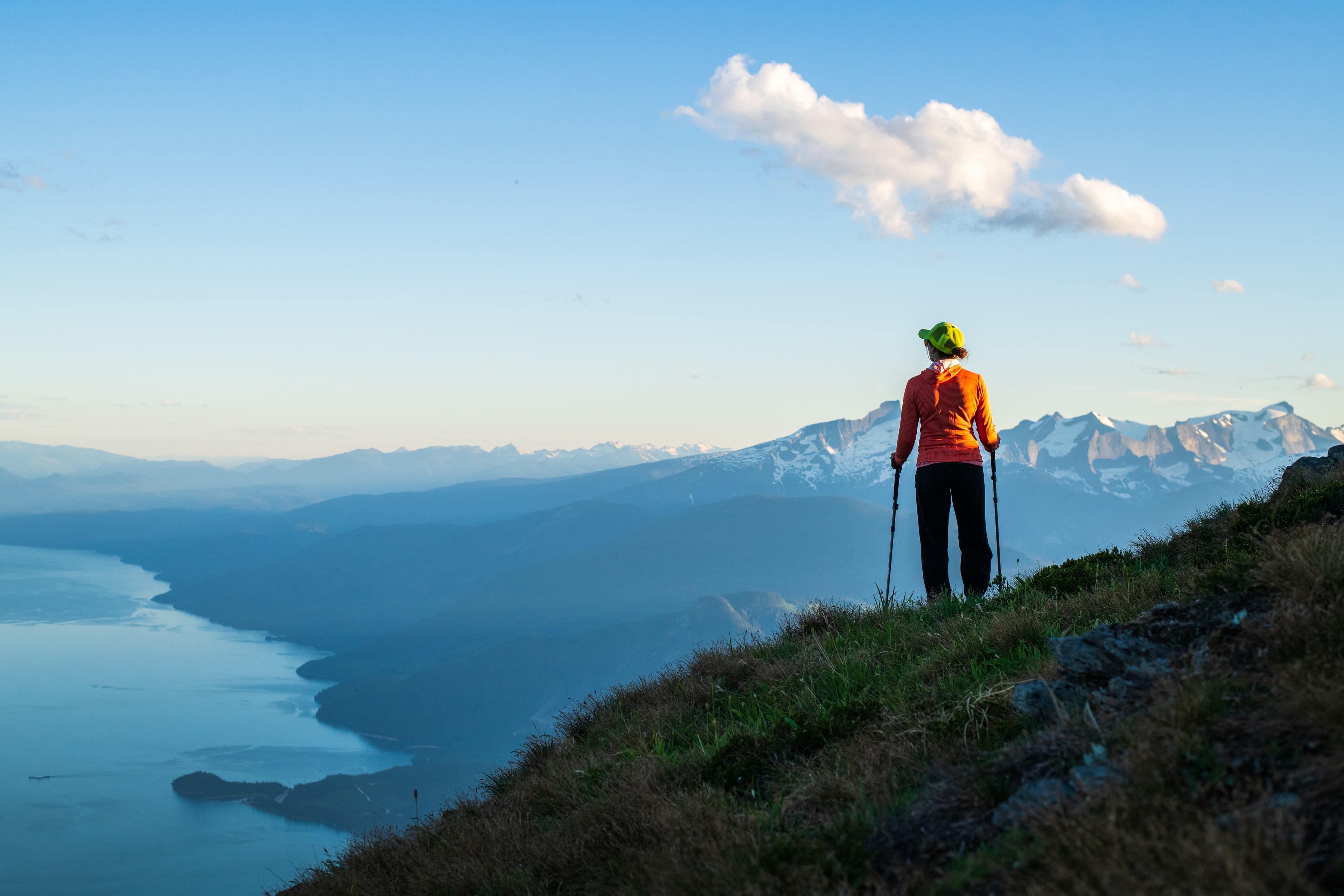 woman looking out at lake and glacier mountain peaks
