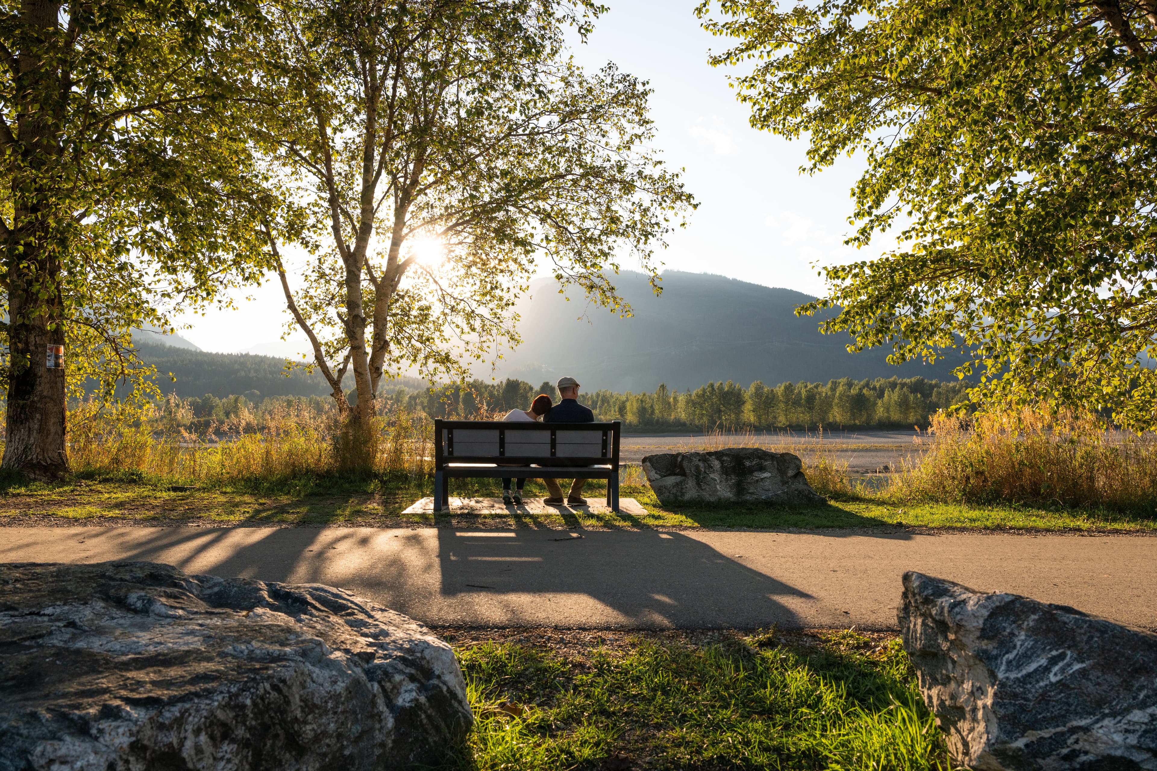 couple sitting on bench along pathway