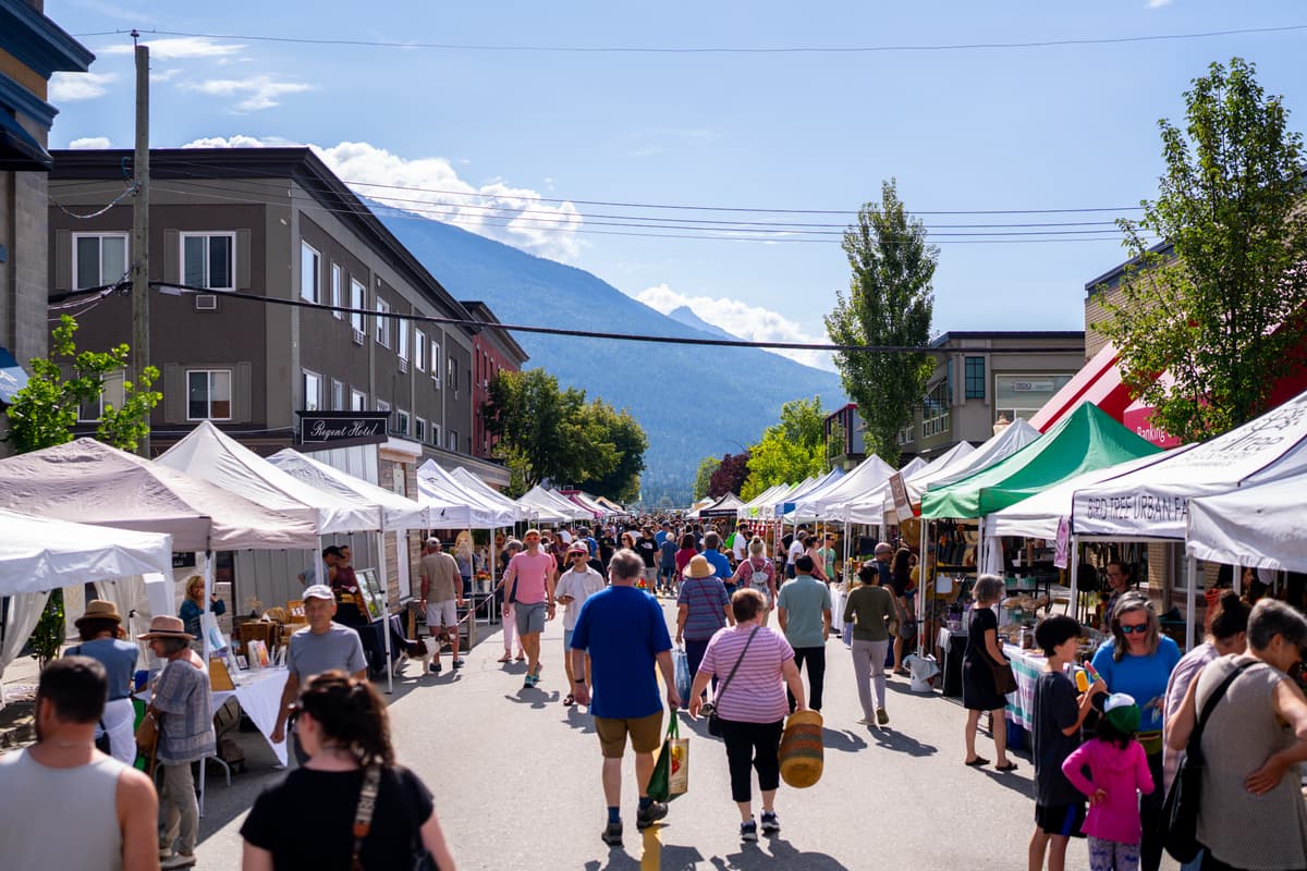 people walking through farmers stands at market