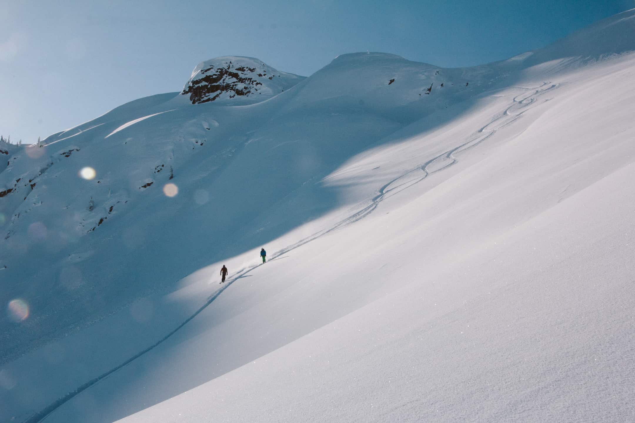 eagle pass heli skiing skiers ski down alpine bowl