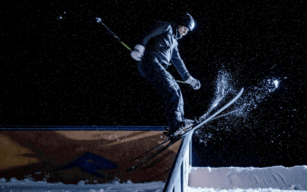 skier riding rail at night