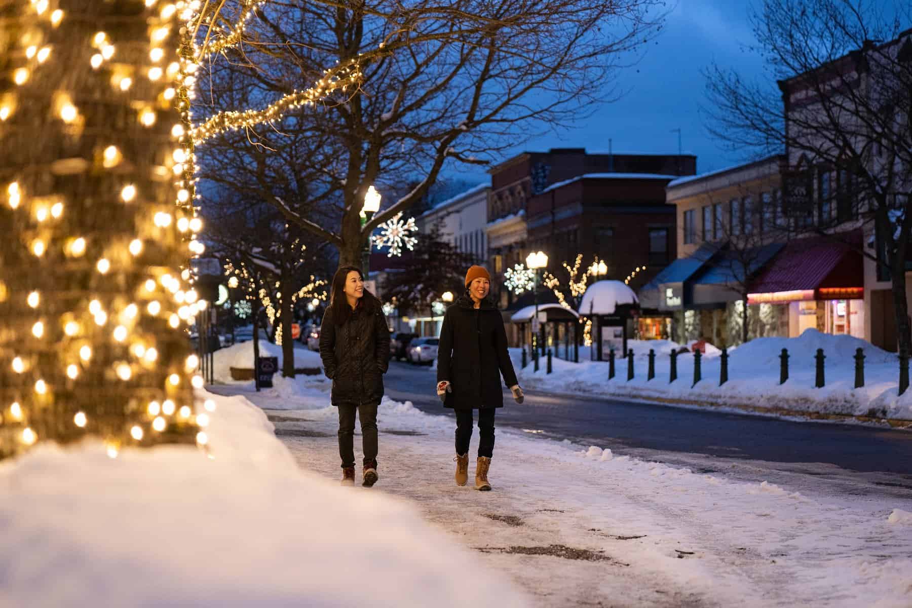 two women walking downtown revelstoke during winter evening
